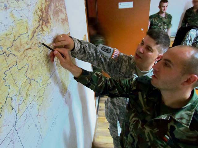 Staff Sgt. Mark Korte, a team sergeant from Company B, 457th Civil Affairs Battalion, 361st CA Brigade, 7th Civil Support Command, shows where his unit was located during his recent Afghanistan deployment in comparison to the deployment location for Bulgarian Army Capt. Galin Ivanov Dobrev, commander of 1st Bde. Module, Civil Military Cooperation team, CIMIC Co., Land Forces at the Gorna Banya Military Base June 11.