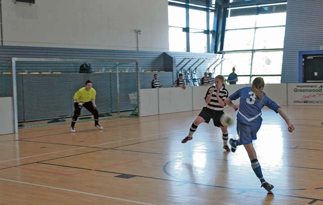 A member of the U.S. Air Forces in Europe and Air Forces Africa women’s soccer team kicks the ball past a Belgian air force player.