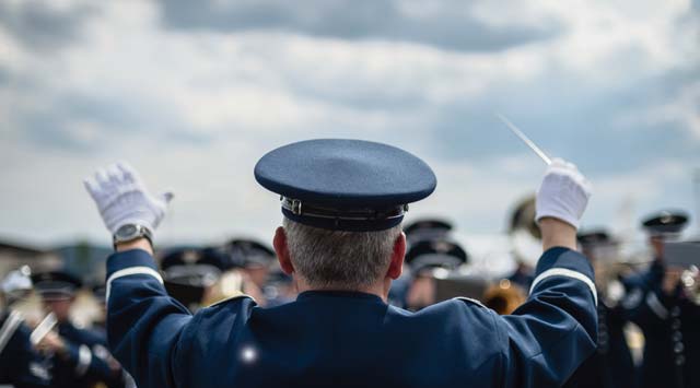 Photo by Airman 1st Class Jordan CastelanLt. Col. Richard Mench, U.S. Air Forces in Europe and Air Forces Africa Band commander, conducts the band  during the sounding of retreat on Ramstein Air Base. The USAFE-AFAFRICA Band and the 86th Aircraft  Maintenance Squadron both took part in retiring the American and German national flags for the day.