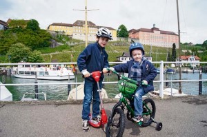 Luke Pelletier, 7, and Jude Pelletier, 4, ride bikes and scooters at the marina in Meersburg, Bodensee.