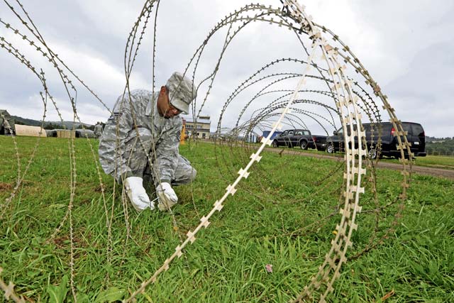 Photo by Senior Airman Chris WillisStaff Sgt. Kenneth Hawkins, 1st Air and Space Communications Squadron client system technician, secures the area around a communication control point Aug. 27, 2013, at U.S. Army Garrison Baumholder, Germany. The exercise gave Airmen a chance to prep a mobile response team capable of staging an airfield in the event of a humanitarian need or mission.  