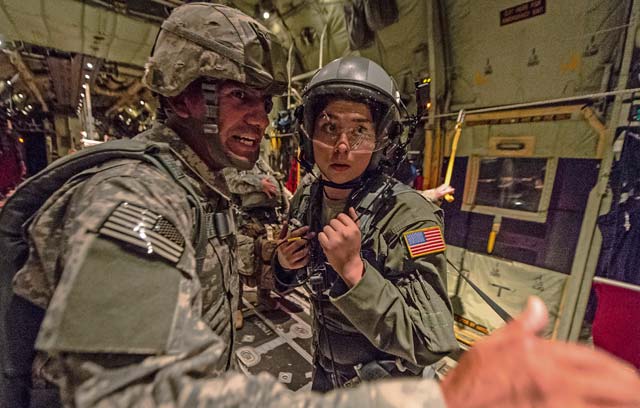 U.S. Air Force Airman 1st Class Emily Mitchell, 37th Airlift Squadron loadmaster, receives the plan of action from U.S. Army Sgt. 1st Class Luis Altamirano, 4th Battalion, 319th Airborne Field Artillery Regiment jumpmaster, during a flight to airdrop paratroopers from the 1st Battalion, 503rd Infantry Regiment, 173rd Airborne Brigade, from a 37th Airlift Squadron C-130J Super Hercules during exercise Steadfast Javelin II over Lithuania Sept. 5.