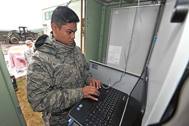 Airman 1st Class James Bautua, 1st Combat Communication Squadron airfield system technician, checks the power input on a tactical air navigation system.