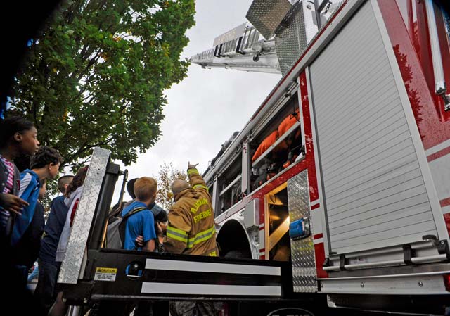 Senior Airman Matthew Clark, 86th Civil Engineer Squadron Fire Department driver and operator, teaches Ramstein Middle School students about fire truck equipment Oct. 9. The 86th CES firefighters came out to the middle school to talk to the students about their job and the importance of fire safety.