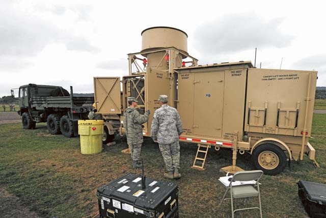 Airmen from the 1st Combat Communications Squadron raise the antenna on a tactical air navigation system during Exercise Market Orchard.