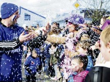 Photo by Senior Airman Hailey HauxA Fasching parade member throws confetti at the crowd as he walks by.