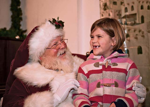 Photo by Staff Sgt. Kris LevasseurRose Taylor, daughter of Lt. Col. Patrick and Terry Taylor, giggles as she  prepares to tell Santa Claus what she wants for Christmas.