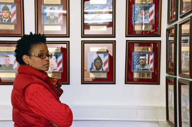 A visitor at the Remembrance Room during opening day looks at some of the 92 photos displayed on the walls.