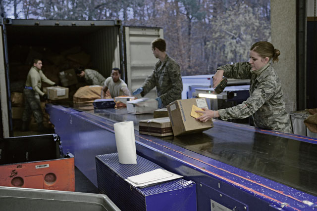 Members of the 86th Communications Squadron post office unload and scan incoming mail Dec. 4 on Ramstein. The post office on Ramstein supports approximately 57,000 KMC members.