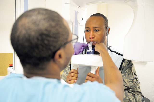 Photo by Airman 1st Class Michael StuartSenior Airman Robert Pace, 86th Dental Squadron dental assistant, adjusts a patient’s mouth piece during a panoramic X-ray. Panoramic X-rays are used to check out the pathology of the mouth and cost around $114 per radiographic.