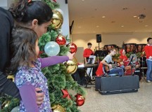 Photo by Rick ScavettaMaria Frutiger and her daughter, Natalia, 5, listen to the  Kaiserslautern High School band perform during this year’s Holiday Spirit Drive, where Army Air Force and Marine Corps groups collected donated gifts for needy families in the KMC.