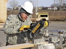 Spc. Francisco Ochoa, a carpentry and masonry specialist with the 902nd Engineer Company (Vertical), 15th Engineer Battalion, 18th Engineer Brigade, 21st Theater Sustainment Command, saws a wooden board during a construction project at the Mihail Kogalniceanu Air Base Passenger Transit Center Jan. 14.