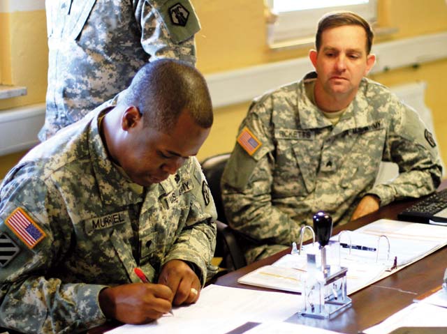 Spc. Juan D. Murriel (left) and Sgt. Wesley R. Ricketts, both human resource specialists with the 406th Human Resources Company, 7th Civil Support Command, process Soldiers, Airmen, Sailors, Marines and civilians in support of exercise Unified Endeavor 14-1 Sept. 16 to Oct. 25 in Grafenwöhr. The multinational, joint exercise supports training of personnel who will deploy in support of the International Security Assurance Force mission in Afghanistan.