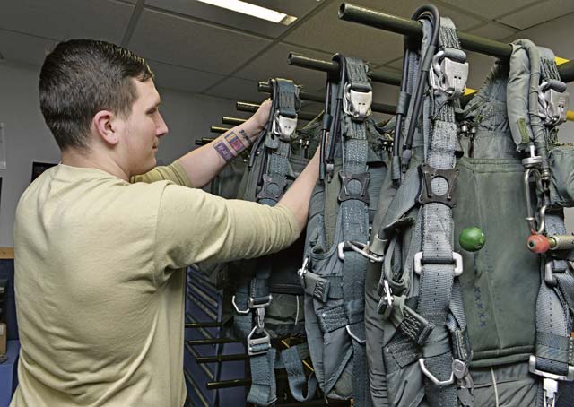 Senior Airman Joseph Namio, 86th Operations Support Squadron aircrew flight equipment  technician, places a finished parachute on a rack.