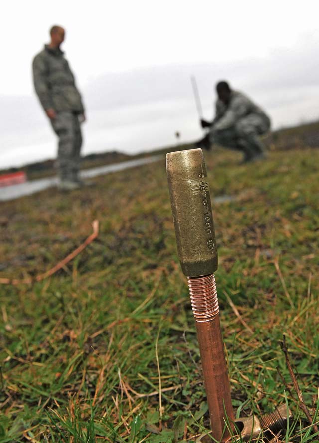 Tech Sgt. Franklin Furman, 786th Civil Engineer Squadron electrical power production NCOIC, and Staff Sgt. Darryl Brown, 786th Civil Engineer Squadron electrical power production craftsman, disconnect a slide hammer from a grounding rod.