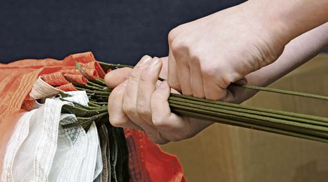 An 86th Operations Support Squadron aircrew flight equipment technician adjusts each line of a parachute to prevent tangling.