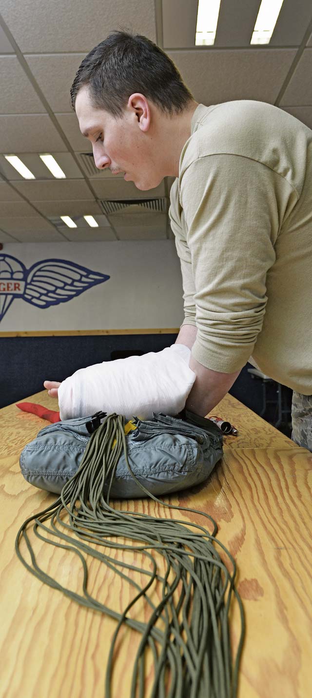 Senior Airman Joseph Namio, 86th Operations Support Squadron aircrew flight equipment technician, folds a parachute to fit inside a pack March 5 on Ramstein. The 86th OSS flight crew equipment Airmen provide life support systems and check parachutes every 180 days to ensure mission readiness and the safety of pilots and crew members.