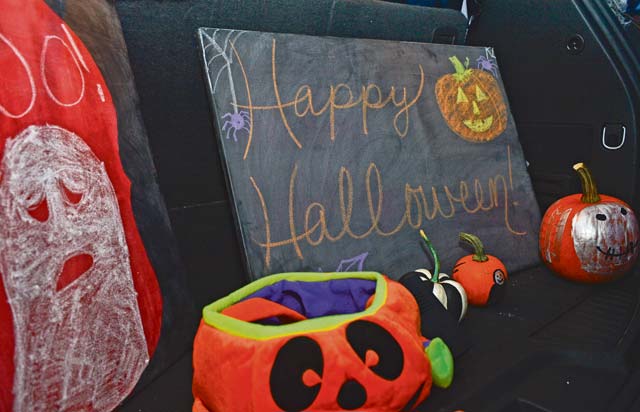 Trunks of cars are lined with Halloween decorations and candy at Donnely Park.