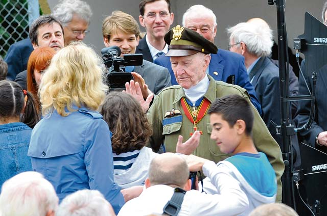 Retired Col. Gail Halvorsen, the “candy bomber”, high-fives members of a school choir after their performance at the commemoration ceremony  of the 65th anniversary of the Berlin Airlift June 26 in Frankfurt, Germany. The members of the youth choir gave Halvorsen candy after their  performance as a way to thank him for his actions during the Berlin Airlift. 