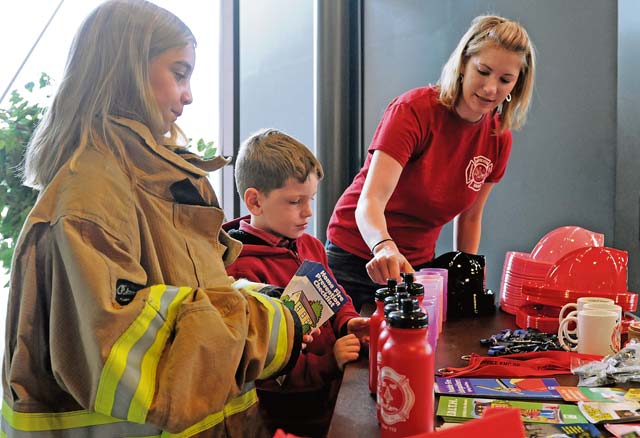 (From left) Hailey, Colton and Jenna Ratlief, family of Senior Airman James Ratlief, 86th Civil Engineer Squadron firefighter, set up souvenirs Oct. 11 during Fire Prevention Week.