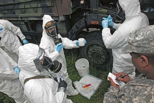 Staff Sgt. Wendell Reeder (right), survey team chief, 773rd Civil Support Team, 7th Civil Support Command, writes notes as he observes members of the HAZMAT Company, Civil Protection Regiment, Kosovo Security Forces, during a Defense Threat Reduction Agency-led exercise May 20.