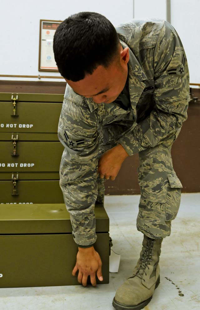 Airman 1st Class Christian Afaisen, 86th Munitions Squadron conventional maintenance crew member, stacks boxes to prepare for a 100 percent accountability inspection.