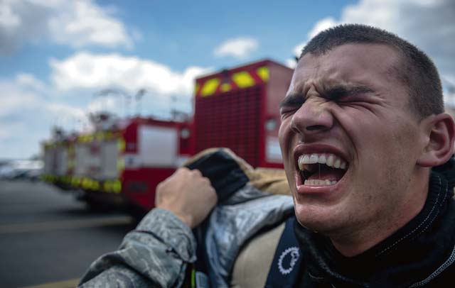 Photo by Airman 1st Class Jordan CastelanAirman Alexander Garratt, 86th Civil Engineer Squadron firefighter, cries out in exhaustion. Competitors had to put on full protective fire gear, sprint to the top of a two-story tower and pull a fire hose weighing 45 pounds through the window and sprint down to the bottom floor, hit a 165-pound steel beam with a nine-pound hammer until it moved forward five feet, negotiate through a 100-foot serpentine course, drag a hose 75 feet and knock  down a target with a stream of water. To end the course, firefighters had to drag a 175-pound dummy 100 feet to the finish line.