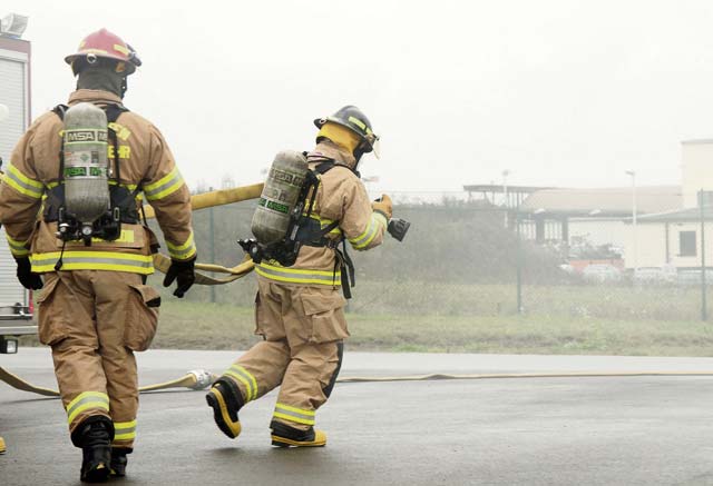 Chief Master Sgt. Frank H. Batten III, 86th Airlift Wing command chief, pulls a hose from a fire engine. 