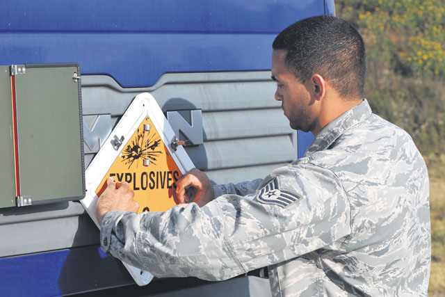 Staff Sgt. Brian Warner, 86th Munitions Squadron munitions storage crew chief, posts an explosive placard on the front of a tractor to ensure  the proper hazard class is displayed while munitions are transported Aug. 22 on Ramstein. The munitions will be transported to an in-transit  munitions facility where they will be shipped in support of worldwide operations. 