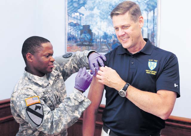 Photo by Brandon BeachMaj. Gen. John R. O’Connor (right), commanding general of the 21st Theater Sustainment Command, receives his flu shot from Sgt. Pierre Jean, health care specialist with U.S. Army Health Clinic-Kaiserslautern, during a 21st TSC command senior leader forum Sept. 18 at Armstrong’s Club  on Vogelweh.