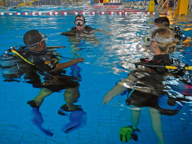 Easy Dive instructor Mike Johnson (center) instructs students  on proper scuba diving techniques.