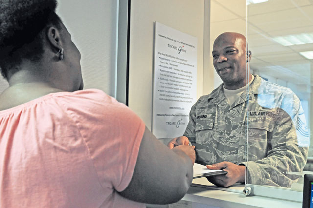 Tanya Hockensmith, 86th Medical Group medical support technician, hands Master Sgt. Charles Higgins, 521st Air Mobility Operations Wing NCOIC air transportation operations, a prescription verification form after he signed in for an appointment  Sept. 5 at the family health clinic on Ramstein. The 86th Medical Group family health clinic recently won Air Force best supporting team by the surgeon general for their highest improvement scores for the quarter.