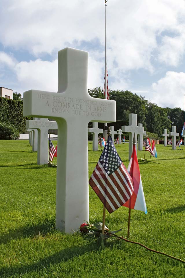 A rose lies next to an unmarked grave during a memorial service at the Luxembourg American Cemetery and Memorial May 26.