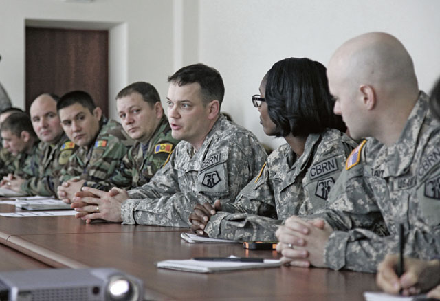 Sgt. 1st Class Ludwig Schweinfurth (center), medical NCOIC with the 773rd Civil Support Team, 7th Civil Support Command, speaks with Moldovan army Nuclear, Biological, Chemical Company Soldiers during a U.S. European Command sponsored CBRN capabilities brief and information exchange Dec. 3. 
