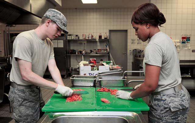 Airman 1st Class Austin Ballinger and Airman Savannah West, 786th Force Support Squadron food services technicians, prepare vegetables for midnight chow.