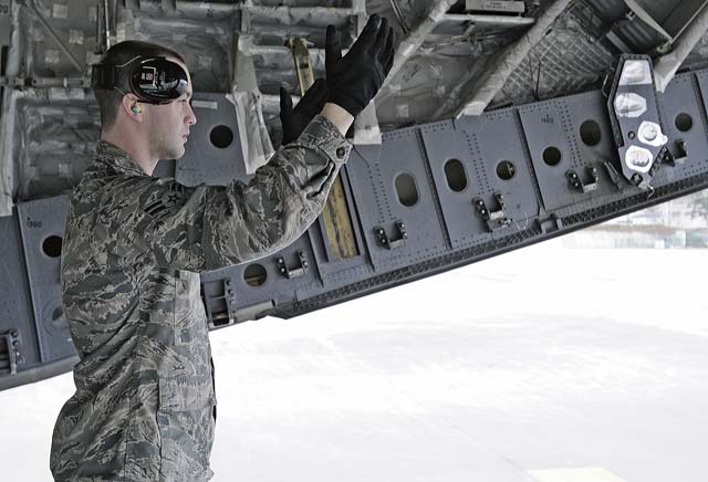 Airman 1st Class Paul Stinnett, 721st Aerial Port Squadron ramp specialist, guides a K-loader to fill a Joint Base Lewis-McChord C-17 Globemaster 3.