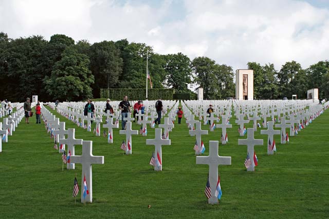 Cub Scouts plant flags during a memorial service at the Luxembourg American Cemetery and Memorial May 26.