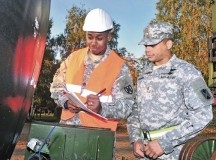 Staff Sgt. Tyler P. Jackson (left), the transportation movement and installation staging area supervisor with the 21st Theater Sustainment Command, reviews a piece of equipment’s serial number with Maj. Ernest J. Harrell, the executive officer of the 5th Battalion, 7th Air Defense Artillery, Oct. 18 on Rhine Ordnance Barracks.