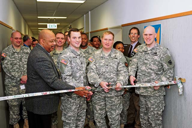 Col. Bryan DeCoster (middle), commander of U.S. Army Garrison Rheinland-Pfalz, prepares to cut the ceremonial dollar bill ribbon Jan. 28, signaling the start of tax season in the KMC. He was joined by tax preparers from the 21st Theater Sustainment Command (front row from left to right) Donald Davis, Kaiserslautern Tax Center coordinator; Capt. Christopher Leighton, tax center officer in charge; and Sgt. Justin Allen, tax center NCOIC.