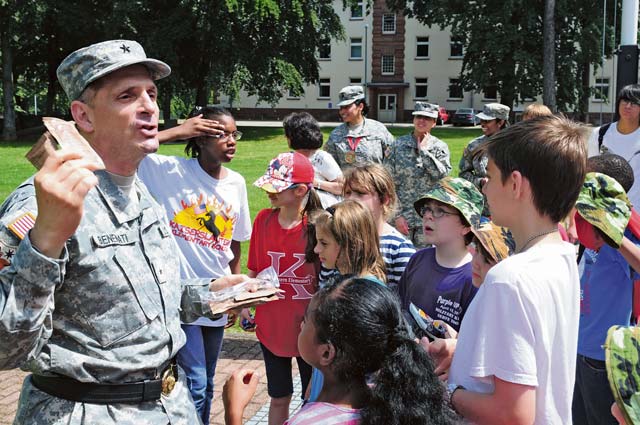 Brig. Gen. Paul Benanati, deputy commanding general for the 21st Theater Sustainment Command, talks with school children about Meals Ready to Eat during a German-American partnership event June 10 on Panzer Kaserne.