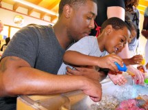 Sgt. Brandon Allums, NCO assigned to the 21st Theater Sustainment Command, helps his son, Khalil, with the creation of “Rainbow Ice” during a science fair Aug. 8 at the Vogelweh Child Development Center.