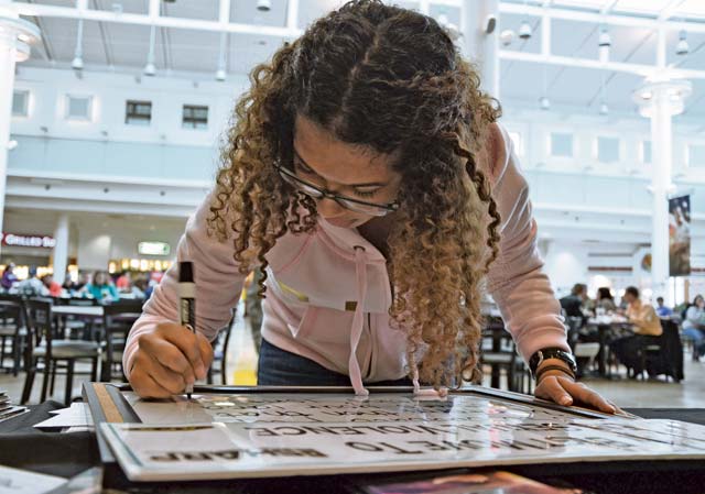 On a white board under the heading “My best move to end sexual violence is,” family member Jade Lovett writes “to educate people and inform them that sometimes your idea of ‘flirting’ isn’t theirs! Don’t cross that line,” during a joint Army and Air Force sexual assault and awareness photo and information booth Jan. 23 at the Kaiserslautern Military Community Center on Ramstein.