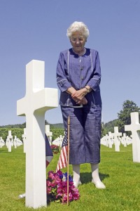 Regine Ruyer, a French World War II survivor and a native of Brouvelieures, France, stands over the grave of Pfc. John Macedo, a Soldier assigned to the 36th Combat Engineer Regiment, who was killed Nov. 1, 1944. Macedo is buried at Epinal American Cemetery and Memorial. Ruyer adopted this grave in 1945 and has placed red, white and blue flowers there every Thursday for the last 68 years.