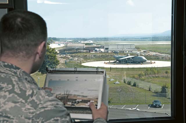 Tech. Sgt. Kristopher Bell, 86th Operations Support Squadron weather flight mission integration function NCO in charge, compares a landscape with the visibility binder photographs Sept. 27 on Ramstein. Visibility binders are used to gauge distances in foggy weather when the primary automatic weather sensing equipment is not in operation.