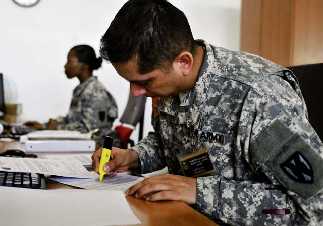 Spc. Cesor D. Silva, human resources Soldier assigned to the 21st Theater Sustainment Command’s 1st Human Resources Sustainment Center, highlights the names of passengers already processed by the U.S. Army Europe Ramstein Gateway Reception Center March 11 at the Ramstein Passenger Terminal.