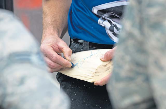 Timbersports athlete David Moses signs his autograph on a piece of wood Oct. 24 on Ramstein. After visiting 786th Civil Engineer Squadron Airmen, the team went on to compete in the World Championship Competition the next day in Stuttgart.