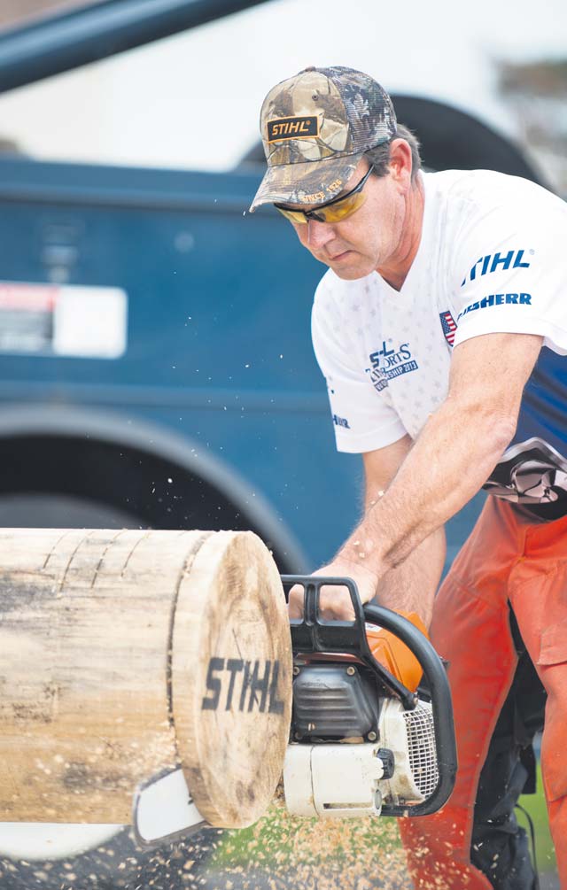 Timbersports athlete Paul Cogar demonstrates how to use a stock saw Oct. 24. 