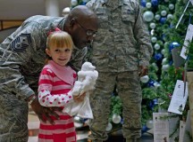 Photo by Airman 1st Class Jordan CastelanSenior Master Sgt. Joseph Wheeler, 721st Aerial Port Squadron first sergeant, prepares to lift Kaity Hart to crown the Angel Tree Nov. 14 on Ramstein. The Angel Tree provides an opportunity for KMC members to donate to families who are undergoing rough times during the holiday season.