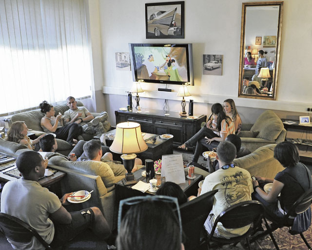 Airmen watch a movie and enjoy a home-cooked meal in the living room of Club 7. Club 7 is the place to go to build a healthy community amongst single Airmen living in the dorms.