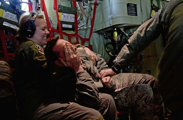 Staff Sgt. Lindsay Rhodes, 86th Aeromedical Evacuation Squadron aeromedical evacuation technician, restrains Staff Sgt. David Meade, 86th Airlift Wing public affairs broadcaster, inside a C-130J Super Hercules.
